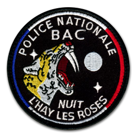 Ecusson de la police nationale de l'hay les roses. L'écusson est rond, noir, et représente en son centre un tigre à dents de sabre de profil, gueule ouverte. A sa droite, une pleine lune blanche. Au-dessus du tigre, il est écrit BAC et en dessous Nuit. Le bord de l'écusson est un liserai bleu blanc rouge.