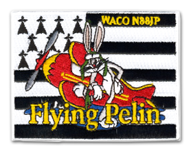 Ecusson brodé du club Flying pelin. L'écusson est rectangulaire horizontal et le fond est le drapeau noir et blanc breton. Devant, un bugs bunny monte dans un petit avion rouge et jaune.